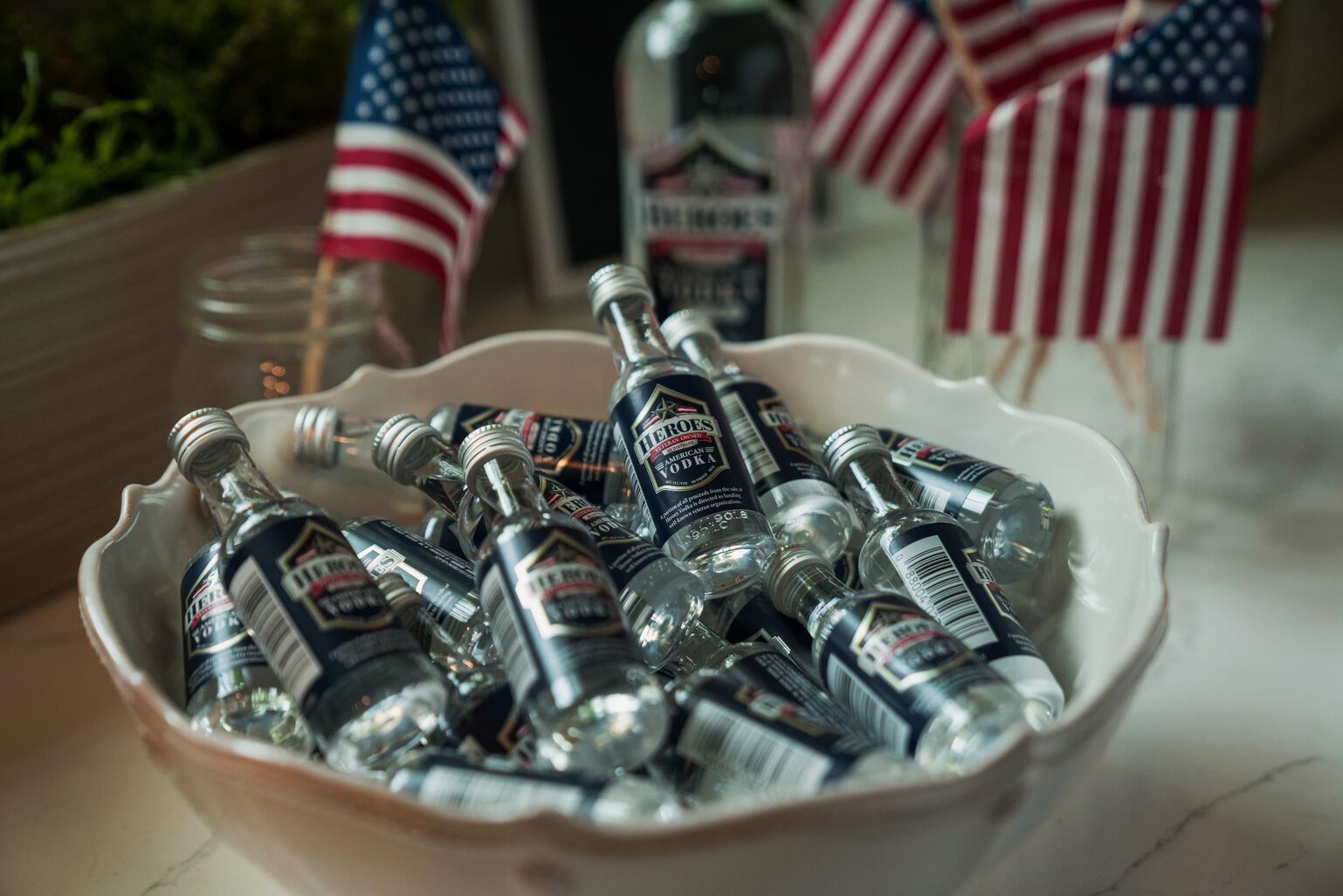 Bottles of Heroes Vodka in a bowl with US Flags in the background
